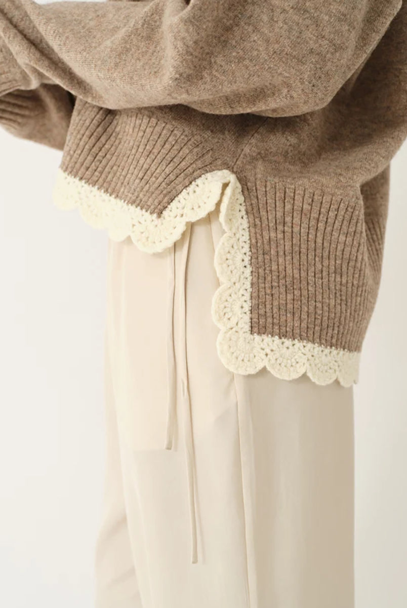 Miękki, luźny sweter Como Crochet Beige Melange z długim rękawem i dekoltem w serek. Dzięki krótszemu przodowi i dłuższemu tyłowi tworzy on korzystną dla sylwetki, swobodnie układającą się linię. U dołu wykończony jest delikatną koronką dodającą subtelnego charakteru. Wykonany z mieszanki wełny i kaszmiru.
-Dekolt w serek
-Wykończony pasem z koronki
-Tkanina z wełną i kaszmirem
