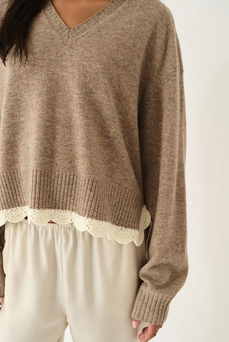 Miękki, luźny sweter Como Crochet Beige Melange z długim rękawem i dekoltem w serek. Dzięki krótszemu przodowi i dłuższemu tyłowi tworzy on korzystną dla sylwetki, swobodnie układającą się linię. U dołu wykończony jest delikatną koronką dodającą subtelnego charakteru. Wykonany z mieszanki wełny i kaszmiru.
-Dekolt w serek
-Wykończony pasem z koronki
-Tkanina z wełną i kaszmirem