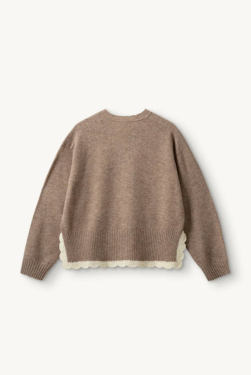 Miękki, luźny sweter Como Crochet Beige Melange z długim rękawem i dekoltem w serek. Dzięki krótszemu przodowi i dłuższemu tyłowi tworzy on korzystną dla sylwetki, swobodnie układającą się linię. U dołu wykończony jest delikatną koronką dodającą subtelnego charakteru. Wykonany z mieszanki wełny i kaszmiru.
-Dekolt w serek
-Wykończony pasem z koronki
-Tkanina z wełną i kaszmirem