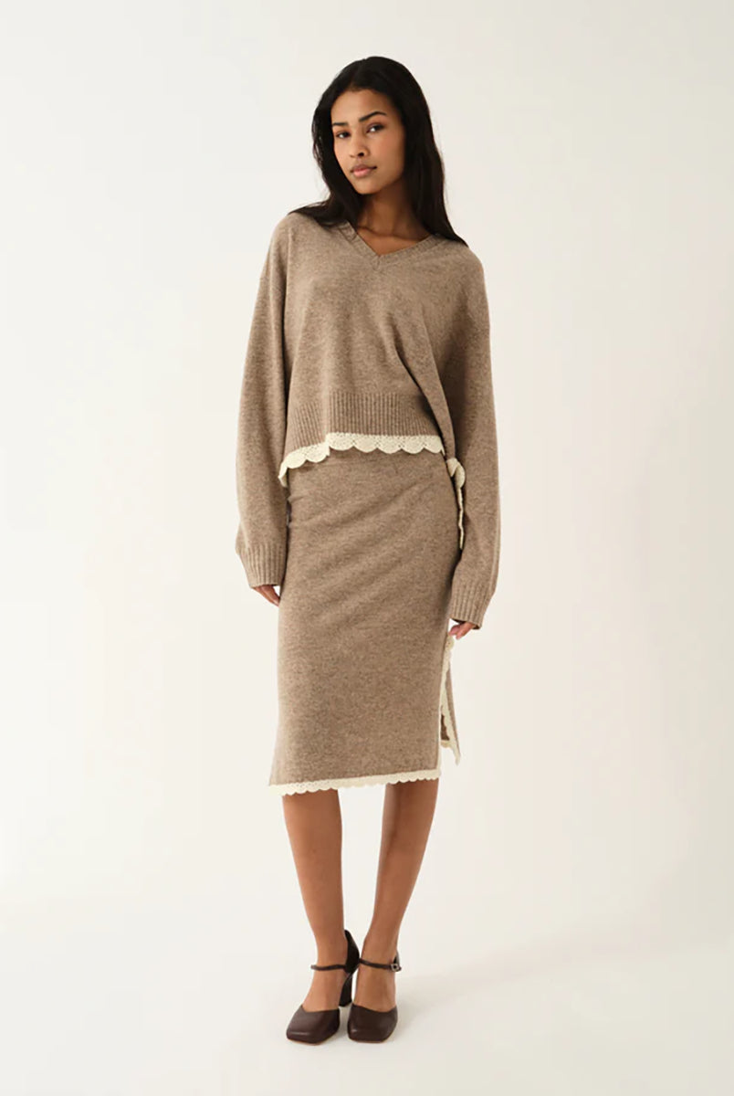 Spódnica Como Crochet Beige Melange typu "slip" wyróżnia się nowoczesnym, smukłym krojem oraz rozcięciami po obu stronach, które zapewniają swobodę ruchów i wygodę. Jej minimalistyczny fason pięknie podkreśla sylwetkę, a boczne rozcięcia dodają całości subtelnego charakteru i zapewniają przewiewność. Ma długość za kolano. Wykonana z mieszanki wełny i kaszmiru.
-Minimalistyczny fason
-Zakończona koronką
-Tkanina z wełną i kaszmirem