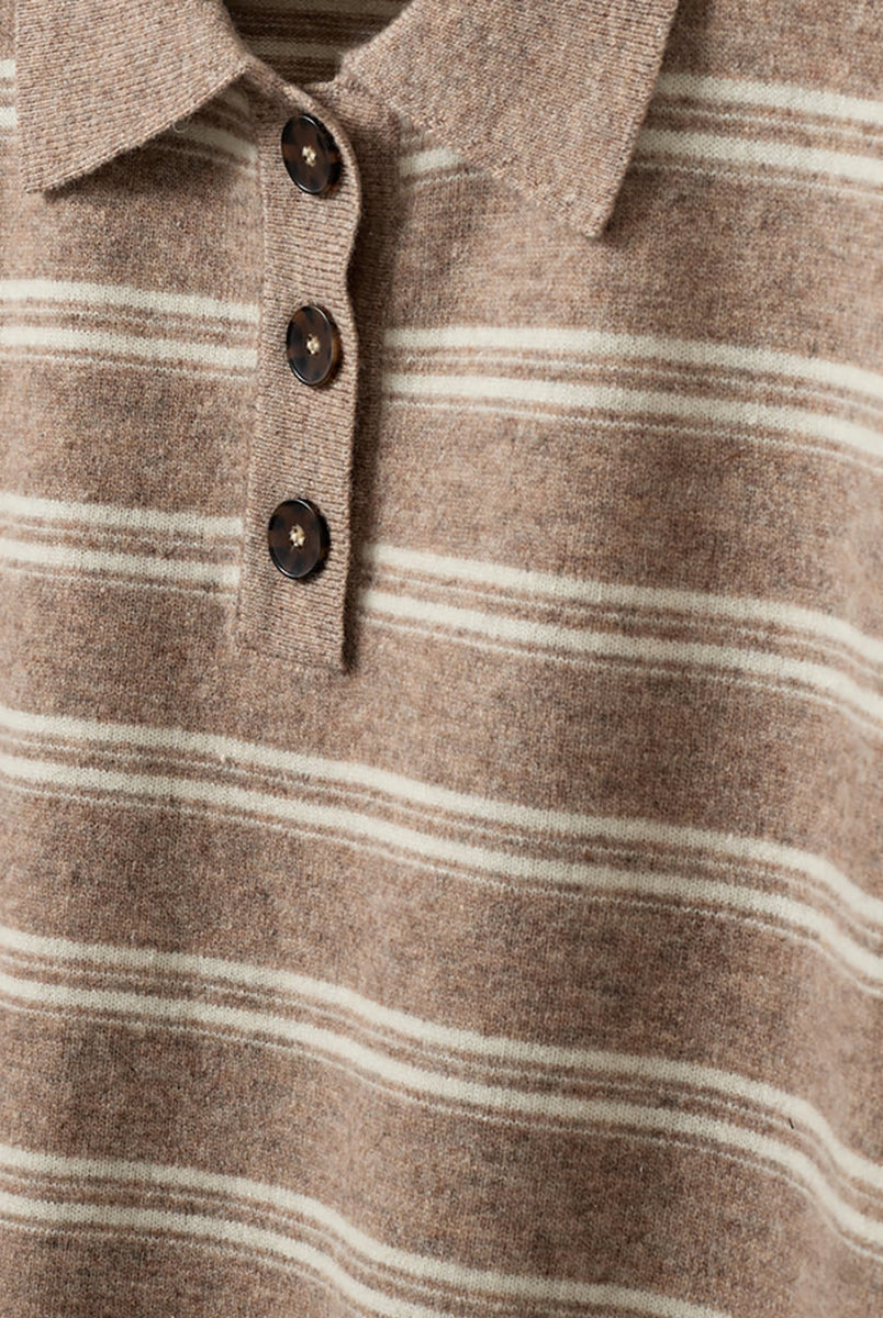 Luźne, dzianinowe polo Como Beige Melange/Cream Stripe w paski, z klasycznym kołnierzykiem zapinanym na trzy guziki. Rękawy i dół zakończone są klasycznymi ściągaczami. Wykonane z tkaniny z wełną i kaszmirem. Krótki rękaw i luźny fason zapewnia przewiewność oraz swobodę ruchów. Zestaw go z ulubionymi jeansami, aby uzyskać klasyczną, modną stylizację.
-Kołnierzyk z guzikami
-Tkanina z wełną i kaszmirem