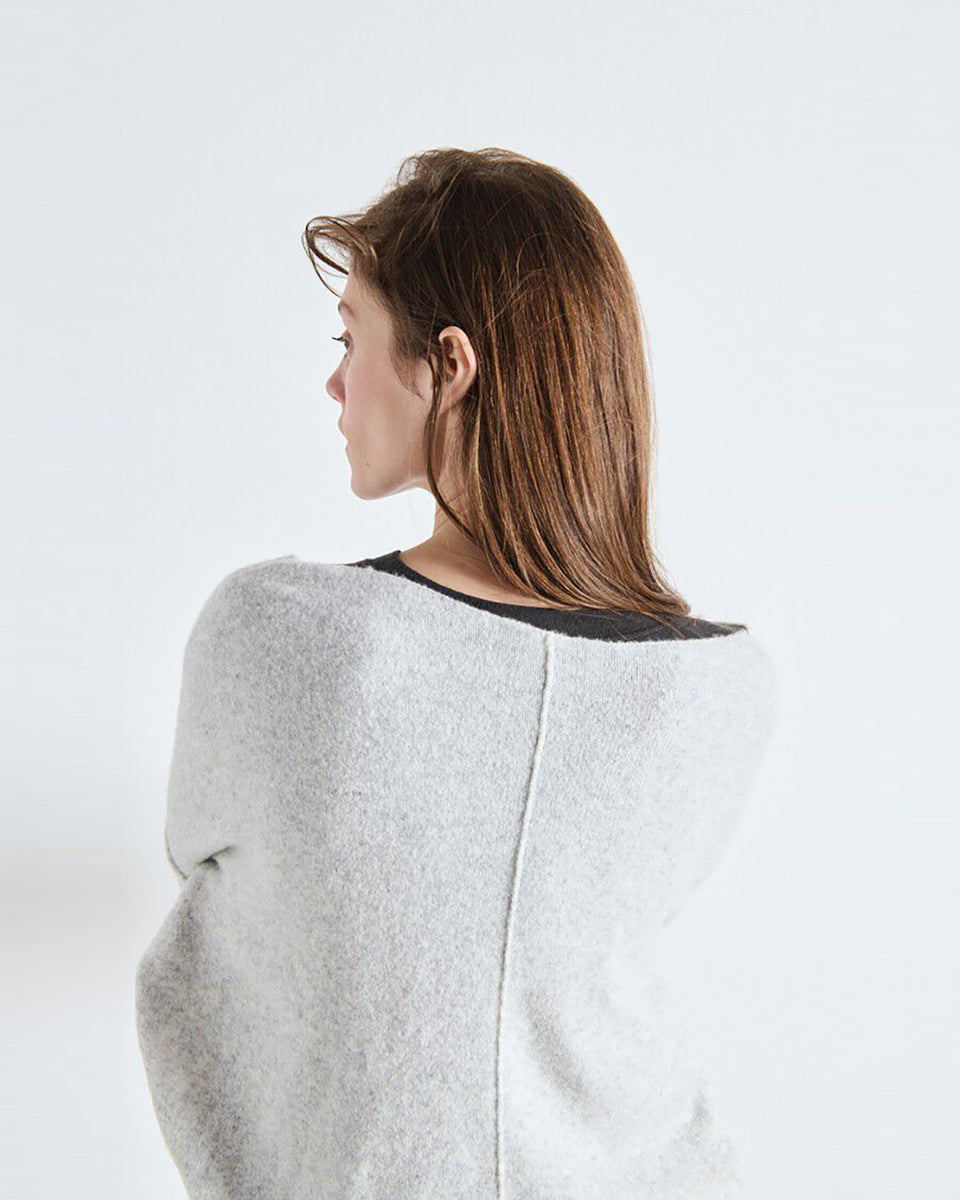 Luźny sweter DAM225 American Vintage Gris Chine w jasnoszarym melanżowym kolorze. Ma obniżoną linię ramion i szeroki, łódkowaty dekolt wykończony surowym brzegiem. Na plecach widoczne jest pionowe przeszycie biegnące przez środek. Materiał ma wyraźną, lekko ziarnistą strukturę przypominającą dzianinę o drobnym splocie. Wykonany z mieszanki z poliamidem i wełną.
-Luźny krój
-Obniżona linia ramion
-Dekolt łódka
-Zamów sweter w swoim standardowym rozmiarze