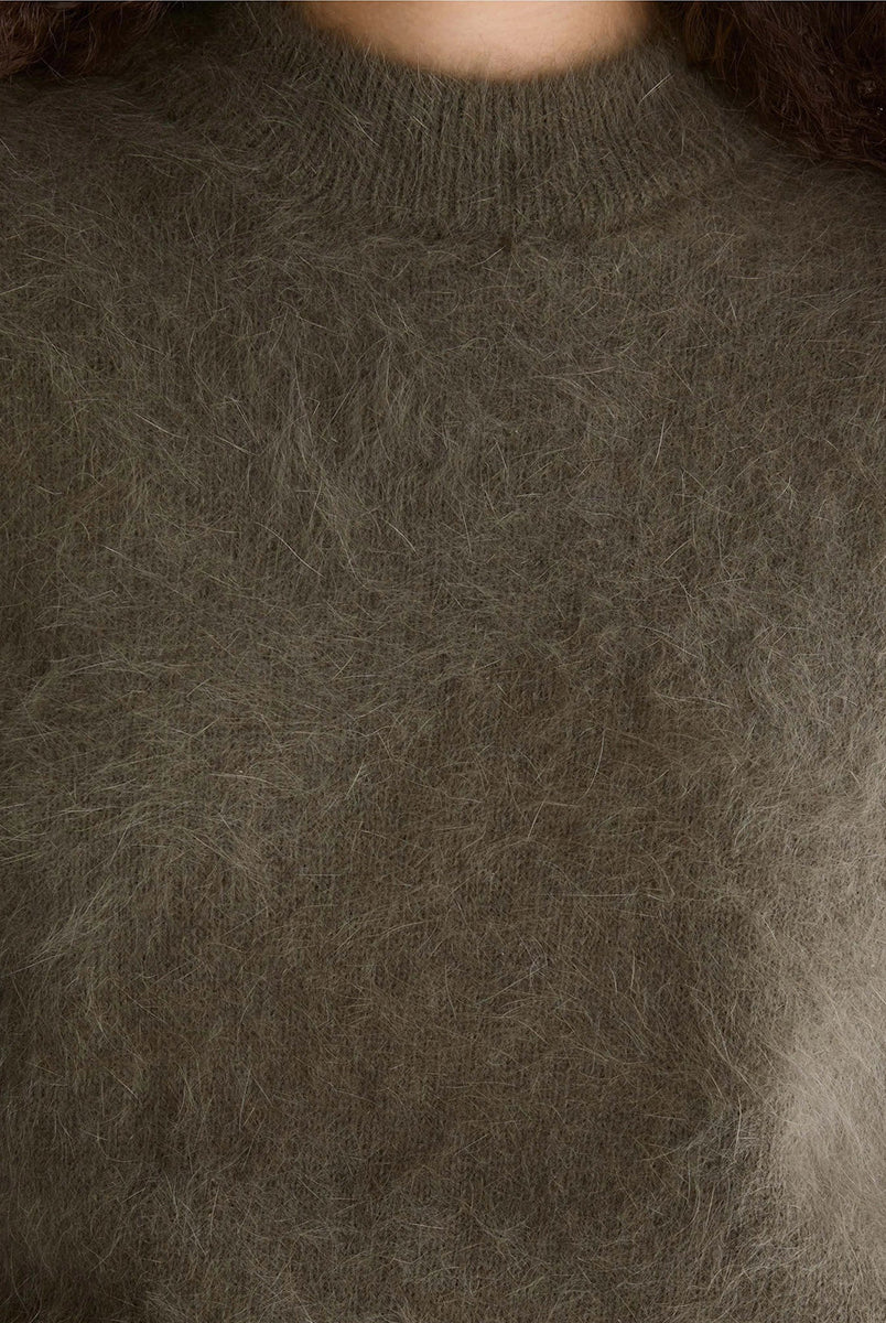 Miękki sweter z dzianiny Dateko Dusty Olive marki Bellerose z okrągłym dekoltem i długimi, prostymi rękawami. Zakończony ściągaczami. Wykonany z mieszanki z dodatkiem angory w kolorze oliwkowej zieleni.
-Luźny fason: zapewnia więcej swobody i komfortu w okolicach klatki piersiowej i ramion
-Miękka dzianina z angorą
