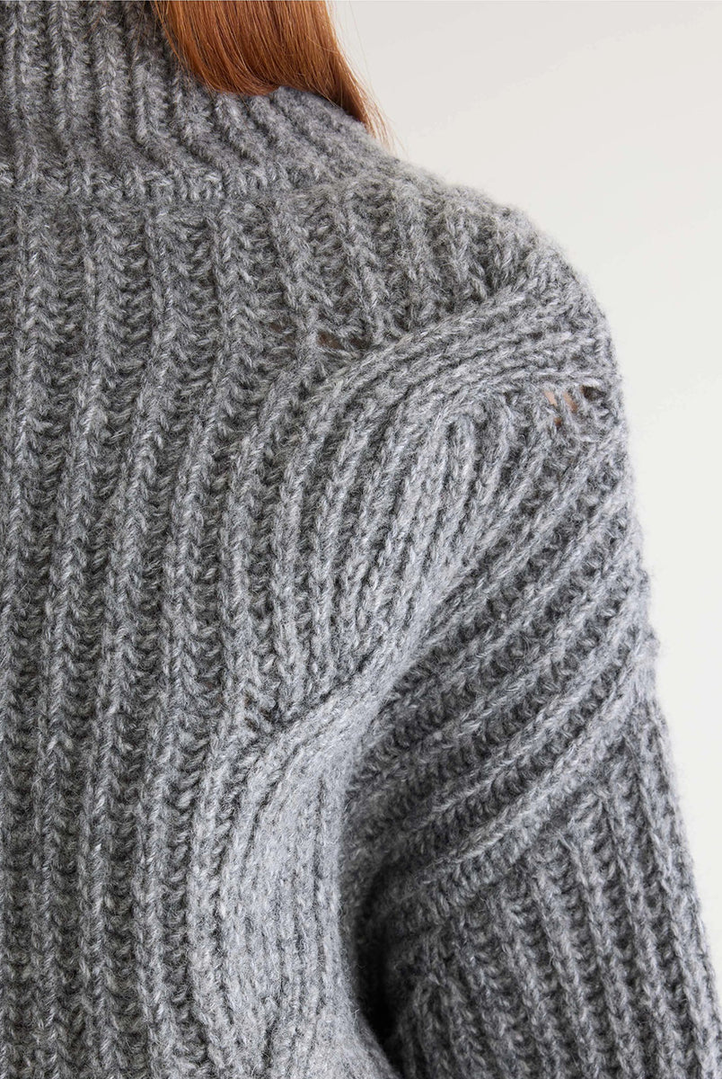 Szary sweter z golfem Deteo Mid Grey marki Bellerose o kroju oversize. Wykonany ściegiem typu "full cardigan", wyróżnia się bardzo grubym splotem ściągaczowym oraz dużymi wzorami warkoczowymi korpusie i rękawach.
-Krój oversize: celowo powiększony fason zapewniający obszerną, luźną sylwetkę
-Golf
-Warkoczowy splot 