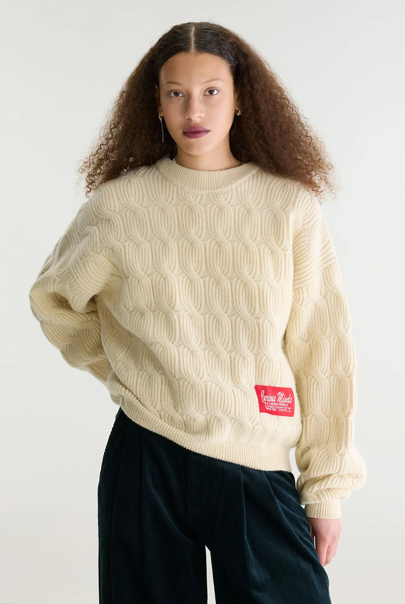 Sweter o luźnym kroju i okrągłym dekolcie Dole Ivory marki Bellerose wykonany z dzianiny w kolorze ecru o splocie ściągaczowym z motywem warkoczowym. Wyróżnia się obszerną górną częścią, zwężanym dołem, krótszym, dwuwarstwowym wykończeniem dekoltu oraz zewnętrzną naszywką.
-Luźny krój: zapewnia więcej swobody i komfortu w obrębie klatki piersiowej oraz ramion
-Splot ściągaczowy 1x1 z motywem warkoczowym
-Zwężany dół