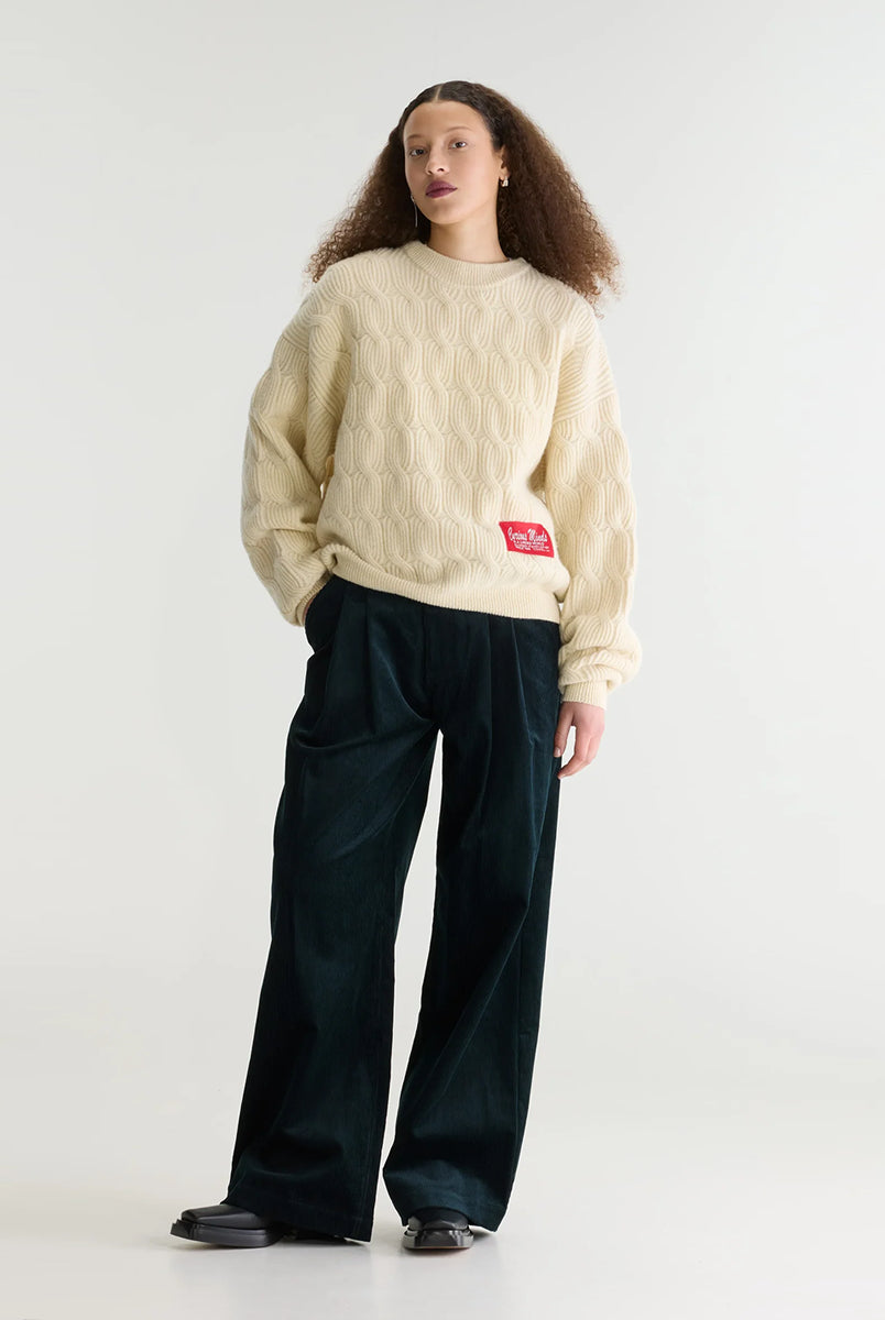 Sweter o luźnym kroju i okrągłym dekolcie Dole Ivory marki Bellerose wykonany z dzianiny w kolorze ecru o splocie ściągaczowym z motywem warkoczowym. Wyróżnia się obszerną górną częścią, zwężanym dołem, krótszym, dwuwarstwowym wykończeniem dekoltu oraz zewnętrzną naszywką.
-Luźny krój: zapewnia więcej swobody i komfortu w obrębie klatki piersiowej oraz ramion
-Splot ściągaczowy 1x1 z motywem warkoczowym
-Zwężany dół