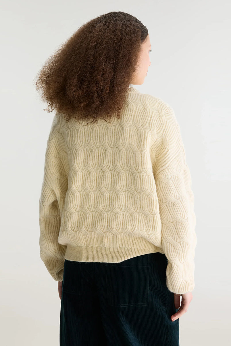 Sweter o luźnym kroju i okrągłym dekolcie Dole Ivory marki Bellerose wykonany z dzianiny w kolorze ecru o splocie ściągaczowym z motywem warkoczowym. Wyróżnia się obszerną górną częścią, zwężanym dołem, krótszym, dwuwarstwowym wykończeniem dekoltu oraz zewnętrzną naszywką.
-Luźny krój: zapewnia więcej swobody i komfortu w obrębie klatki piersiowej oraz ramion
-Splot ściągaczowy 1x1 z motywem warkoczowym
-Zwężany dół