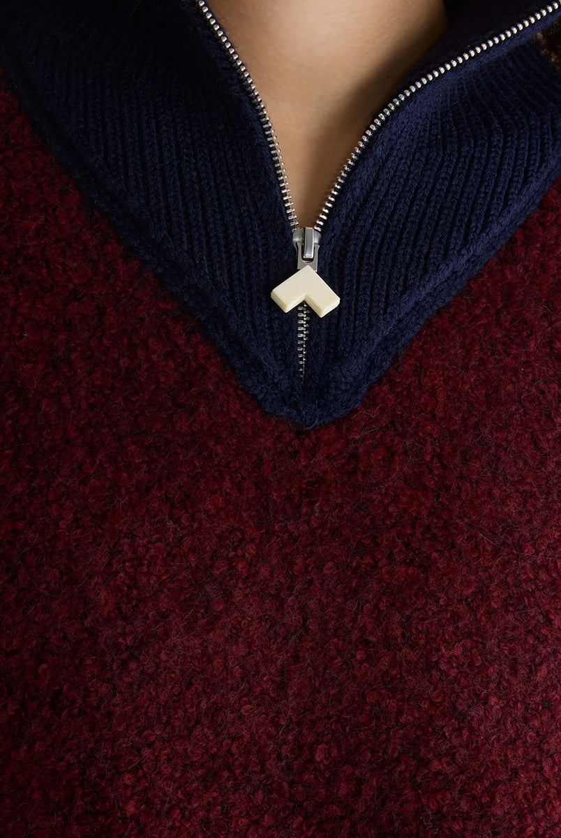 Sweter o klasycznym kroju z bordowej przędzy typu boucle Dooh Wine marki Bellerose wykonany splotem żakardowym imitującym fakturę ręcznika. Wyróżnia się kontrastowym, granatowym, podwójnym golfem z wełny merino, zapinanym na zamek błyskawiczny z uchwytem ozdobionym logo w kształcie serca.
-Krój regularny: zrównoważony fason, który podąża za naturalnymi liniami sylwetki
-Dwuwarstwowy golf zapinany na zamek
-Wyjątkowa przędza i splot żakardowy o fakturze ręcznika 