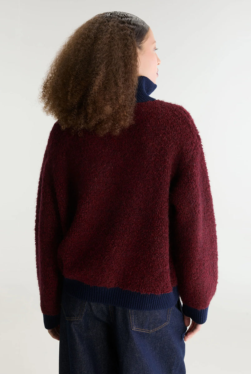 Sweter o klasycznym kroju z bordowej przędzy typu boucle Dooh Wine marki Bellerose wykonany splotem żakardowym imitującym fakturę ręcznika. Wyróżnia się kontrastowym, granatowym, podwójnym golfem z wełny merino, zapinanym na zamek błyskawiczny z uchwytem ozdobionym logo w kształcie serca.
-Krój regularny: zrównoważony fason, który podąża za naturalnymi liniami sylwetki
-Dwuwarstwowy golf zapinany na zamek
-Wyjątkowa przędza i splot żakardowy o fakturze ręcznika 