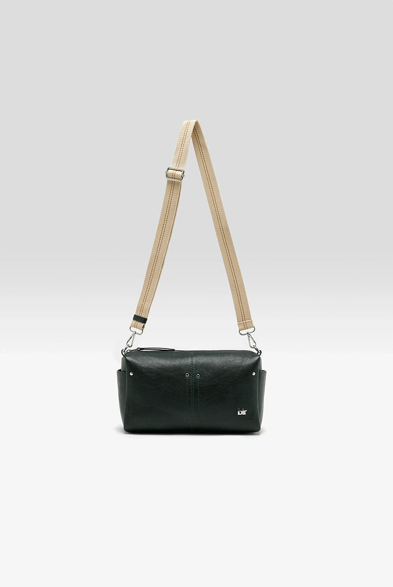 Torebka typu crossbody Duol Bottle Green marki BELLEROSE z teksturowanej, butelkowo-zielonej skóry koziej. Posiada regulowany, odpinany, beżowy pasek bawełniany oraz krótki, skórzany uchwyt. Zapinana na zamek błyskawiczny. Z przodu ma metalowe logo marki. Posiada wewnętrzną kieszeń główną, wewnętrzną kieszeń naszywaną oraz zewnętrzną kieszonkę boczną. 