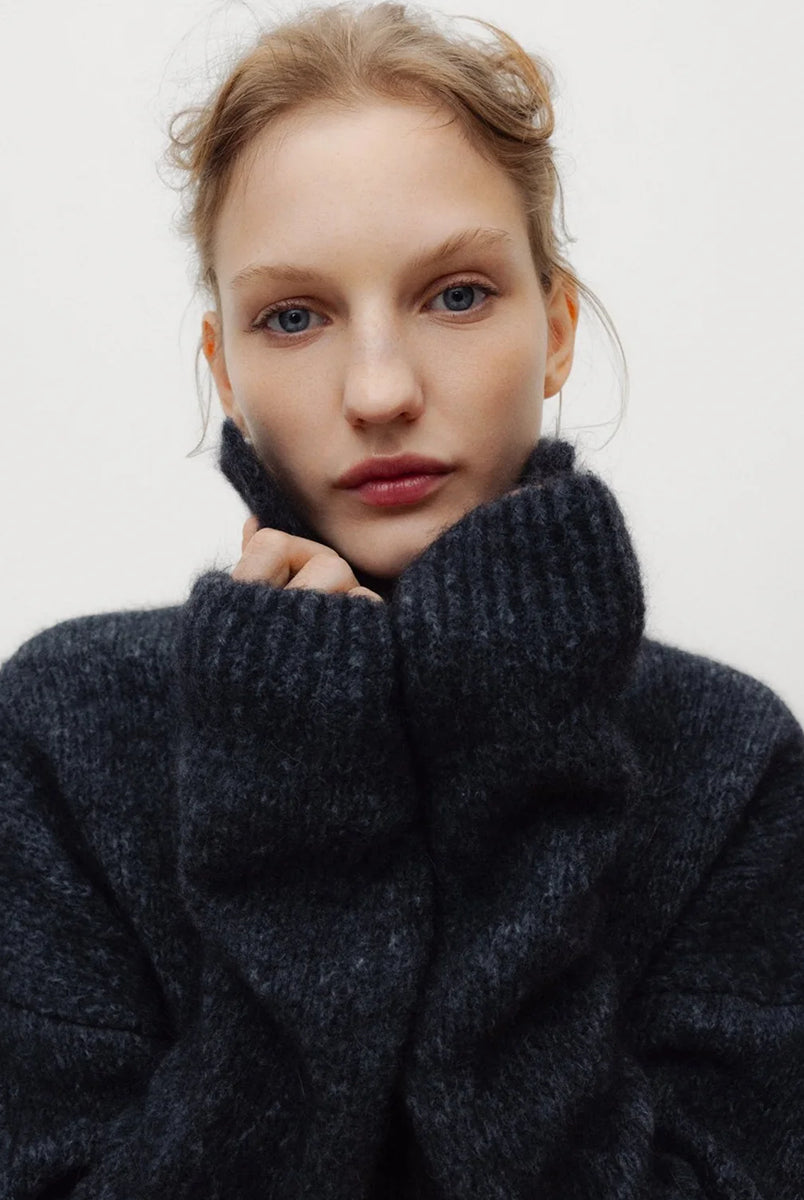 Ciemnoszary, miękki sweter polo Elara TNS Dark Grey Melange z kołnierzykiem, obniżoną linią ramion i ściągaczami. Ma swobodny krój, czyniąc ją ponadczasową dzianiną idealną do codziennych, swobodnych stylizacji. Wykonany z luksusowej mieszanki alpaki i wełny dziewiczej.
-Obniżona linia ramion
-Kołnierzyk polo
-Zamów sweter w swoim normalnym rozmiarze 