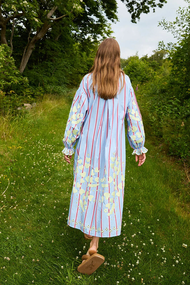 Haftowana, oversizowa sukienka maxi w czerwono-różowe paski Elisabeth Bluebell Stripes SISSEL EDELBO z długimi, szerokimi rękawami i opadającymi ramionami. Mankiety rękawów są zwężane i wykończone uroczą falbanką. Sukienka ma okrągły dekolt. Na dekolcie zapinana jest za pomocą drobnych guzików z masy perłowej. Wykonana jest ze zwiewnej bawełny organicznej z haftem z motywem serc. Posiada długość przed kostki.
-ONE SIZE
-Oversize
-100% bawełna organiczna