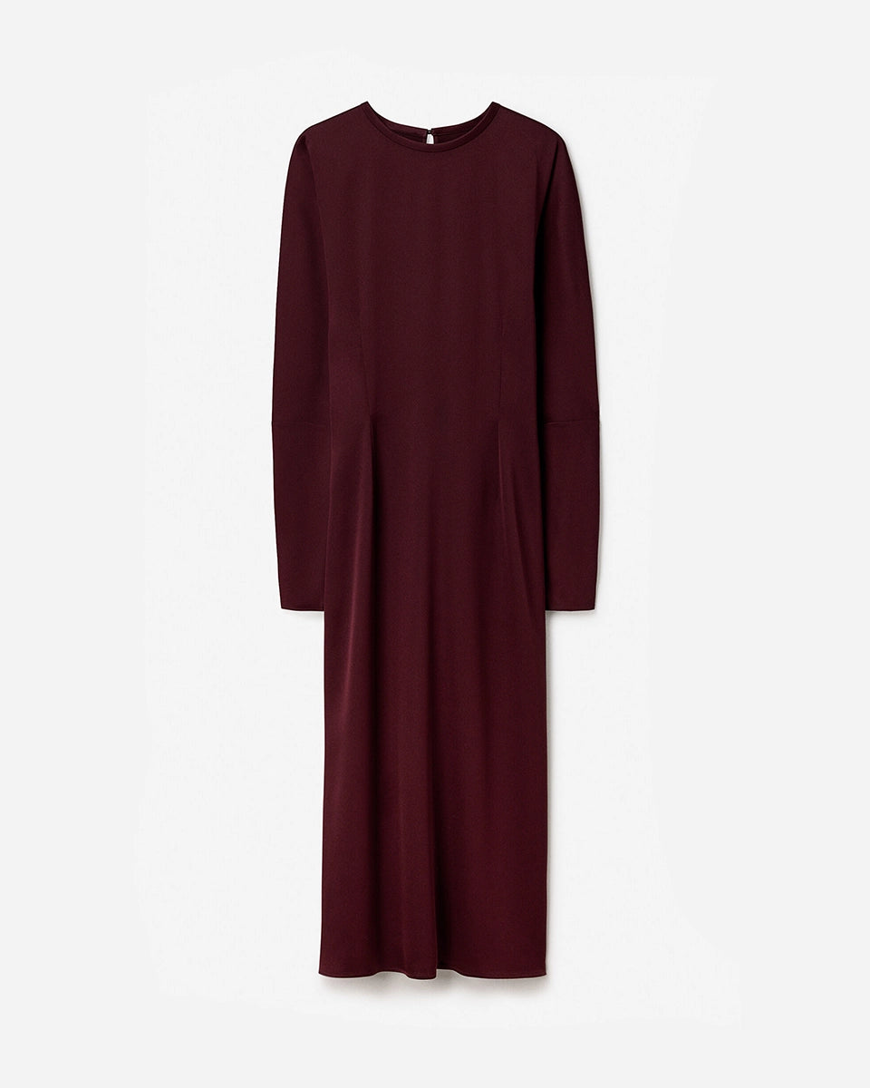 Minimalistyczna, luźna, elegancka sukienka midi Filippa K z okrągłym dekoltem i długimi rękawami rozszerzanymi pod pachami z guzikami przy mankietach. Na plecach posiada długie, wąskie rozcięcie. Z tyłu przy szyi zapinana na jeden guzik. Lekko zwężana w talii. Z tyłu w pasie ma elastyczną gumkę.