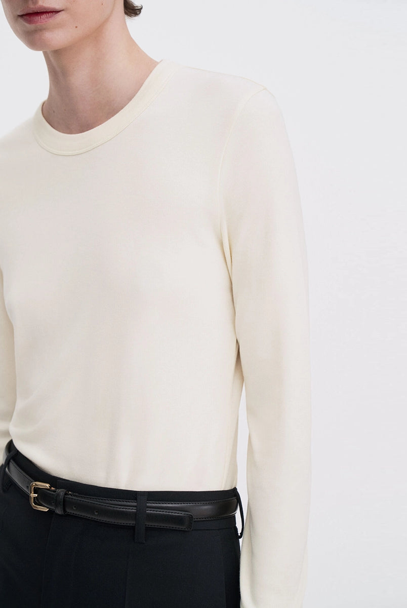Luźny, minimalistyczny longsleeve Filippa K z okrągłym dekoltem i długimi rękawami. Top ma prosty krój. Jest wykonany z bardzo miękkiej i lejącej tkaniny z prążkowaną fakturą.