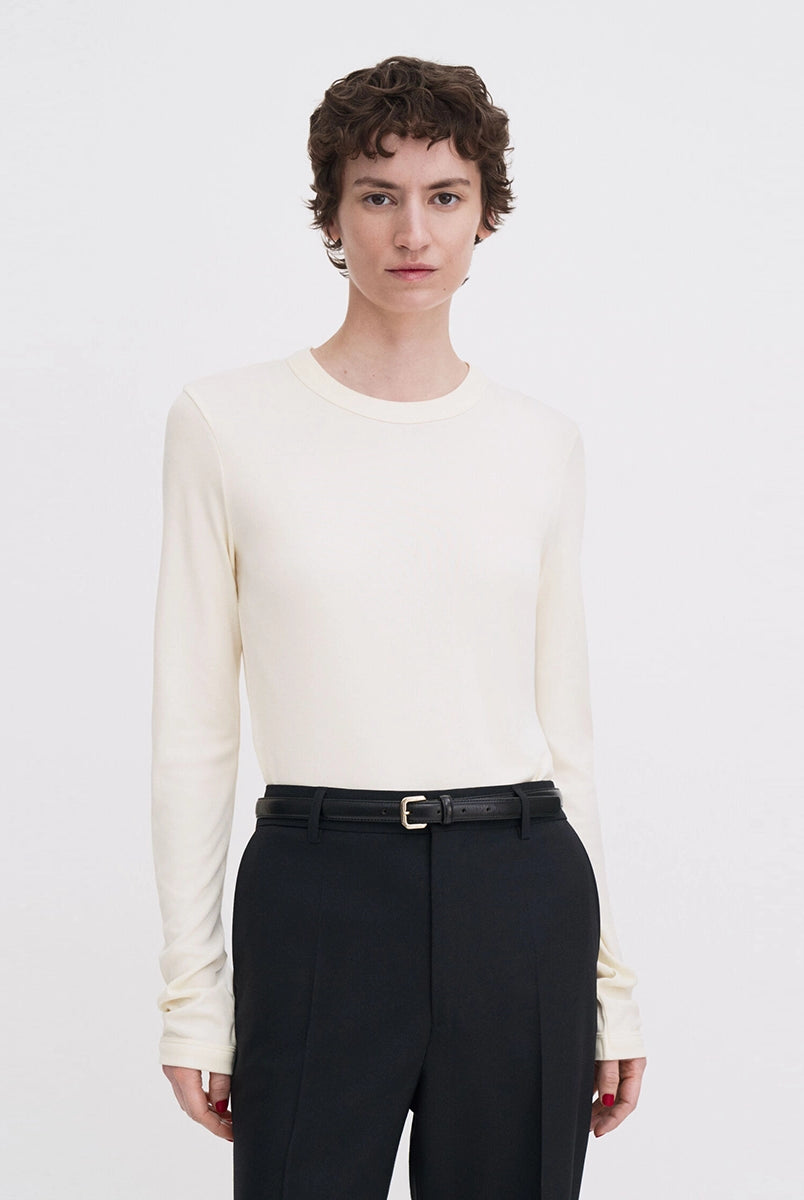 Luźny, minimalistyczny longsleeve Filippa K z okrągłym dekoltem i długimi rękawami. Top ma prosty krój. Jest wykonany z bardzo miękkiej i lejącej tkaniny z prążkowaną fakturą.