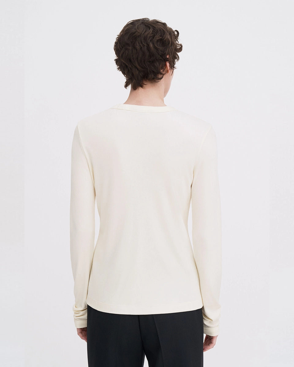 Luźny, minimalistyczny longsleeve Filippa K z okrągłym dekoltem i długimi rękawami. Top ma prosty krój. Jest wykonany z bardzo miękkiej i lejącej tkaniny z prążkowaną fakturą.
