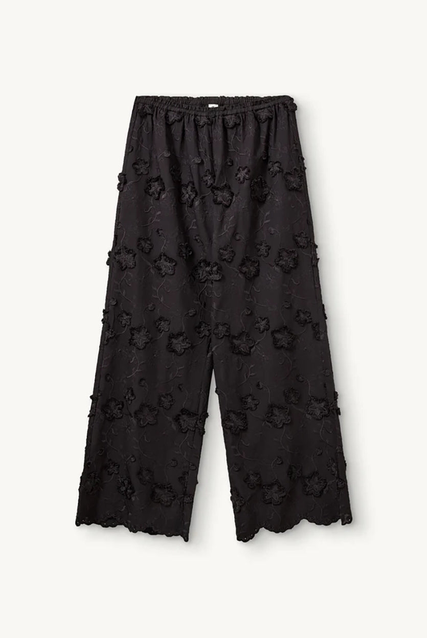 Luźne, proste, czarne spodnie Fleur Black marki The Garment z długimi, szerokimi nogawkami i elastyczną talią z gumką w pasie. Na całej powierzchni naszyte są wypukłe, kwiatowe aplikacje 3D. Dół nogawek wykończony jest naturalnym, falistym brzegiem koronki. Te spodnie to idealna alternatywa dla klasycznej sukienki wieczorowej.
-Luźny krój typu wide-leg
-Wypukłe, kwiatowe aplikacje
-Zamów spodnie w swoim normalnym rozmiarze
