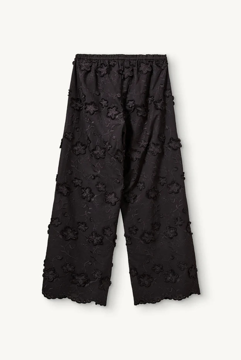 Luźne, proste, czarne spodnie Fleur Black marki The Garment z długimi, szerokimi nogawkami i elastyczną talią z gumką w pasie. Na całej powierzchni naszyte są wypukłe, kwiatowe aplikacje 3D. Dół nogawek wykończony jest naturalnym, falistym brzegiem koronki. Te spodnie to idealna alternatywa dla klasycznej sukienki wieczorowej.
-Luźny krój typu wide-leg
-Wypukłe, kwiatowe aplikacje
-Zamów spodnie w swoim normalnym rozmiarze