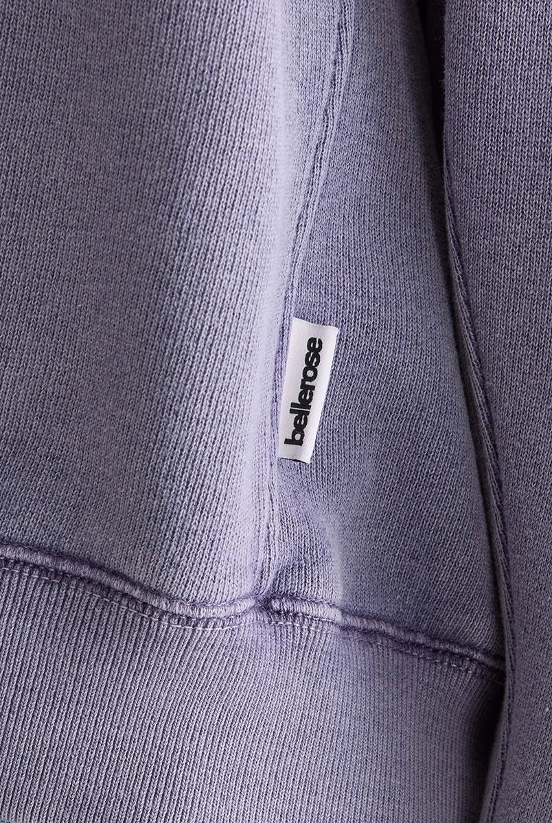 Oversizowa bluza w kolorze spranego fioletu Flips Grape marki BELLEROSE z okrągłym dekoltem, długimi rękawami ze ściągaczami i widocznymi szwami. Bluza ma obniżoną linię ramion i trójkątne przeszycia pod kołnierzem. U dołu posiada elastyczny ściągacz. Wykonana z dzianiny z bawełną.
-Luźny fason. Wybierz swój zwykły rozmiar lub mniejszy, aby uzyskać bardziej dopasowany look.