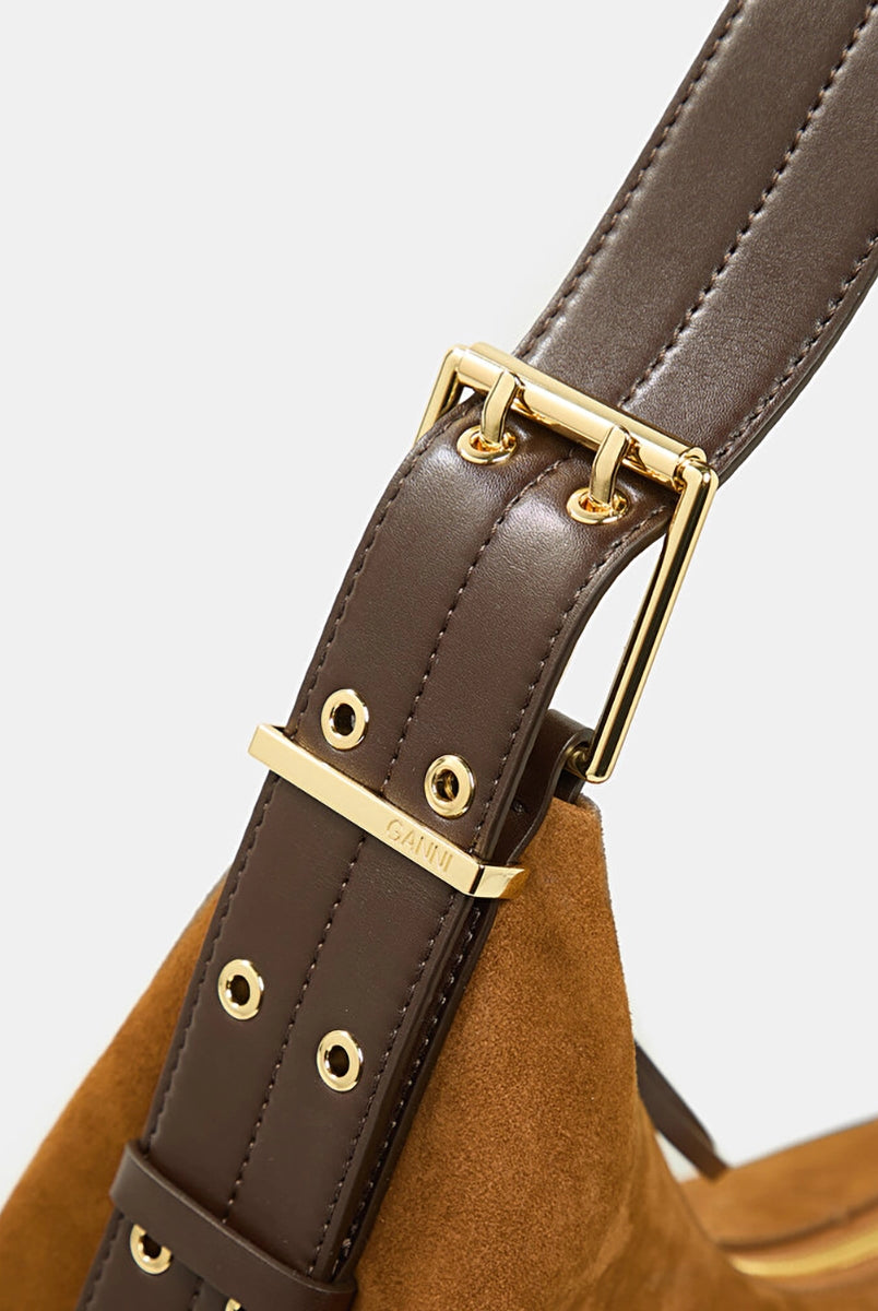 Duża, zamszowa torba w kolorze karmelowym Hobo Belt Medium GANNI z szeroki, regulowanym paskiem z podwójnymi "oczkami" i złotymi detalami. Zapinana na zamek błyskawiczny. Z przodu posiada niewielkie, złote logo marki. Wewnątrz obszyta podszewką. W środku posiada niewielką, zapinaną na zamek kieszonkę na najważniejsze drobiazgi.