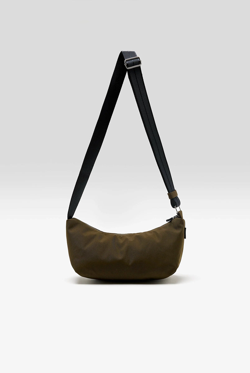 Mała torba typu sling w kolorze khaki Hane Carbone marki Bellerose o miękkiej, zaokrąglonej konstrukcji. Model wyposażony w zapięcie na zamek błyskawiczny; szeroki, regulowany pasek z taśmy, srebrne okucia i wewnętrzną kieszeń. Posiada podszewkę z lekkiego materiału technicznego. 