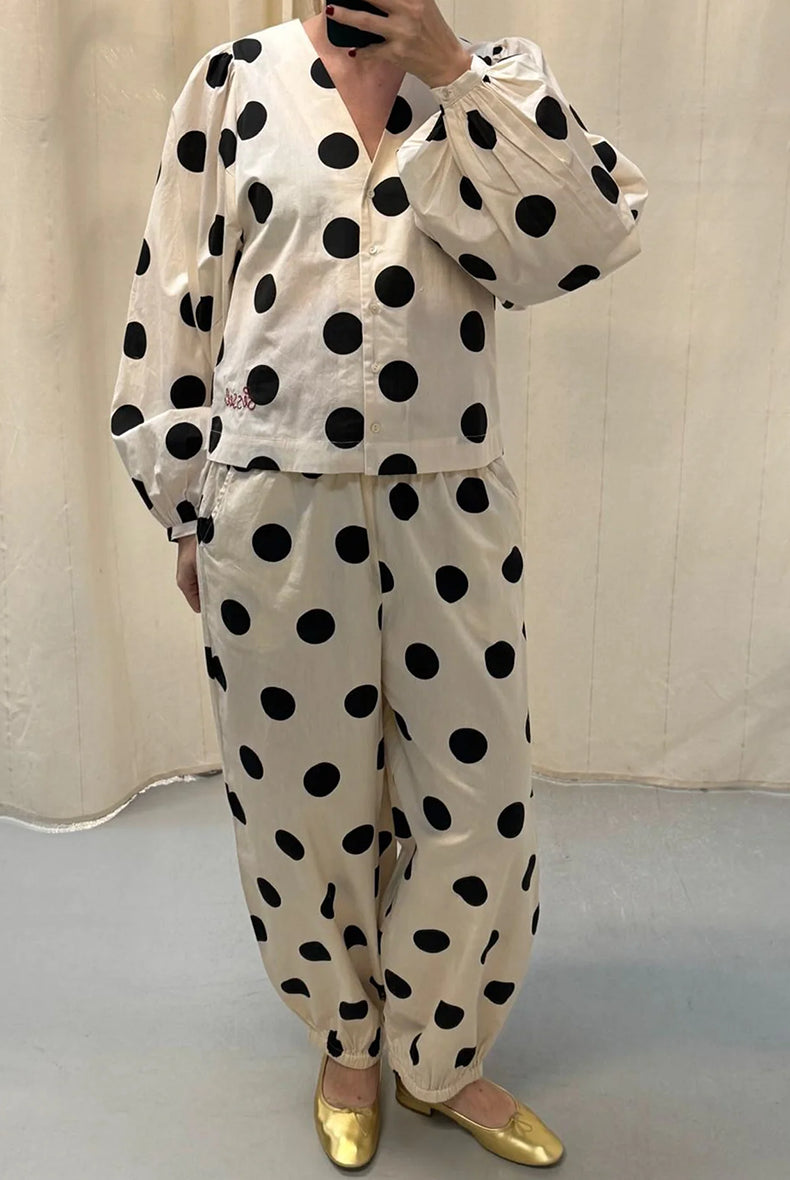 Luźne spodnie Iluna SISSEL EDELBO z żakardowej tkaniny z modnym wzorem polka dots. Posiadają szerokie, luźne nogawki zakończone wąskimi, elastycznymi ściągaczami. Spodnie mają elastyczną talię. Wykonane zostały z tkaniny pozyskanej z postprodukcji, co nadaje spodniom oryginalności i niepowtarzalności.
-Luźny fason
-Lekka tkanina w czarne grochy
-Ręcznie wykonane hafty
-Zamów spodnie w swoim normalnym rozmiarze