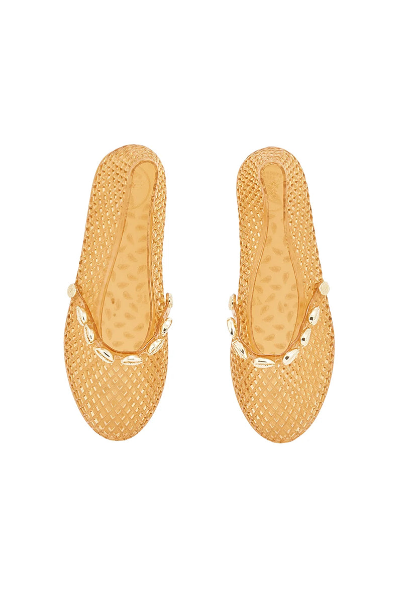 Klasyczne, miękkie baleriny Iro Shells Caramel w w ciepłym, miodowym odcieniu z zaokrąglonym noskiem i płaską podeszwą. Ich charakterystyczną cechą jest ażurowa, pleciona faktura. Z przodu posiadają zapięcie na pasek ozdobiony muszelkami. Wykonane w całości z elastycznej gumy/PVC. Są miękkie, dopasowują się do kształtu stopy i są całkowicie odporne na wodę. To idealne obuwie typu ,city-to-beach'.