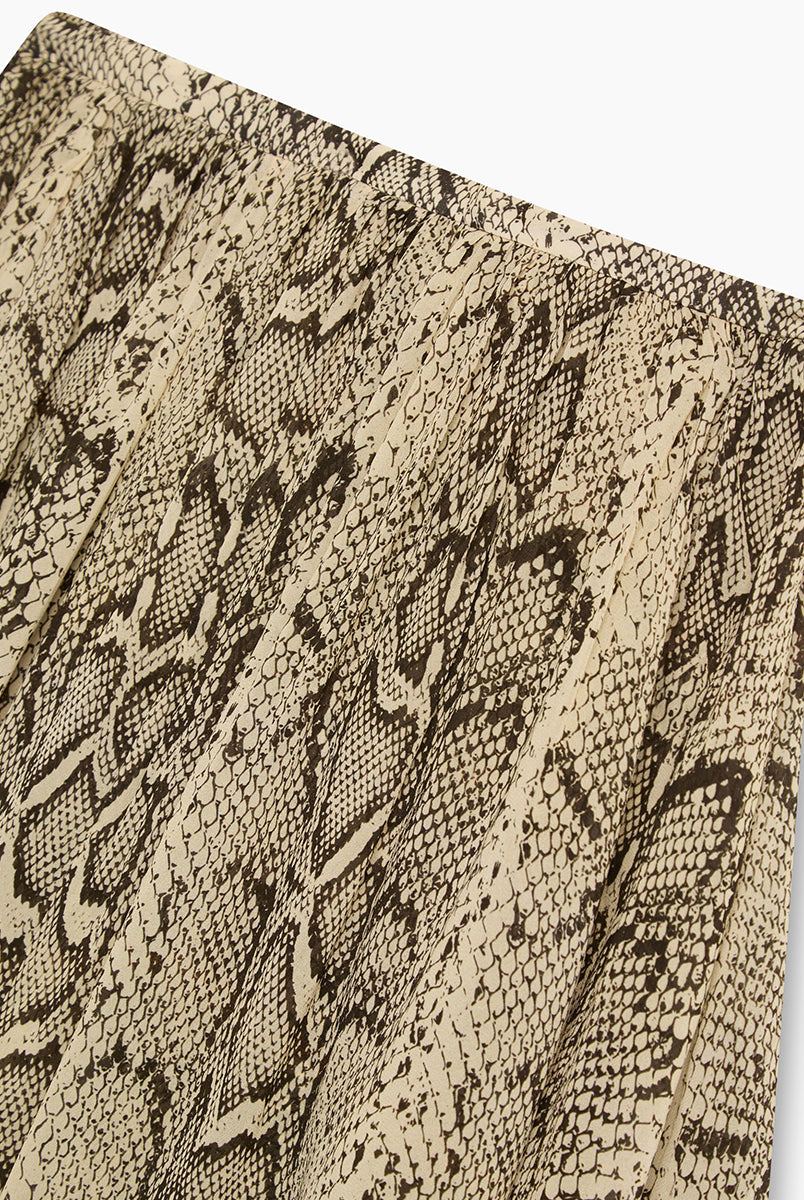 Efektowna, midi spódnica Isley TNS Snake Print wyróżnia się wężowym printem, który łączy w sobie odcienie beżu, brązu, szarości i czerni. Posiada luźny, zwiewny krój z efektownymi kaskadowymi falbanami i asymetrycznym dołem, co nadaje jej dynamicznej objętości oraz lekkości w ruchu. Model ten ma wygodny, elastyczny pas, który subtelnie marszczy materiał u góry. Dzięki warstwowej budowie spódnica pięknie faluje się i stanowi wyrazisty element każdej stylizacji.
-Długość midi
-Asymetryczny krój
-Falbany