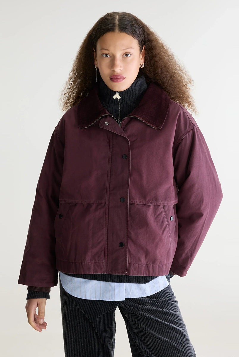 Luźna, sprana kurtka Jazlin Burgundy marki Bellerose w burgundowym kolorze z długimi rękawami i kołnierzem typu baby cord, który można nosić jako komin lub podwinąć jako kołnierzyk koszulowy. Z przodu znajduje się klapa kryjąca ukośne kieszenie, a z tyłu zapięcie na zatrzaski. Zapinana na zamek błyskawiczny i zatrzaski. Posiada pikowaną podszewkę.
-Luźny krój
-Kołnierz typu baby cord
-OVERSIZE. Jeśli chcesz uzyskać efekt zaprezentowany na modelce zamów kurtkę w swoim rozmiarze. Jeśli chcesz żeby by