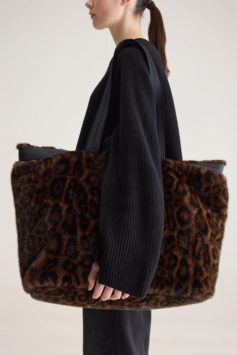 Duża torba typu tote Jommie Leopard marki Bellerose ze sztucznego futra w panterkę. Wyposażona w długie uchwyty z taśmy oraz krótsze- do noszenia w dłoni. Wnętrze wykonane jest z bawełnianego diagonalu z kieszenią na suwak i zapięciem na zatrzask. 