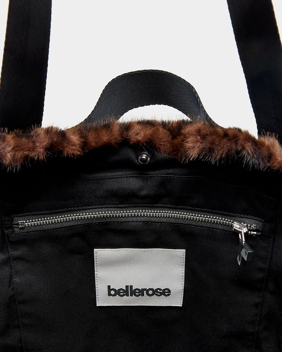 Duża torba typu tote Jommie Leopard marki Bellerose ze sztucznego futra w panterkę. Wyposażona w długie uchwyty z taśmy oraz krótsze- do noszenia w dłoni. Wnętrze wykonane jest z bawełnianego diagonalu z kieszenią na suwak i zapięciem na zatrzask. 