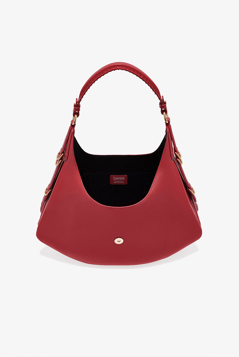 Ponadczasowa, czerwona torebka Kat Small 7077 GANNI Red Dahlia w stylu souffle o zaokrąglonym kształcie, z paskiem na ramię i detalami w kształcie D-ringów z boku. Posiada zapięcie z przodu, z charakterystycznym złotym detalem GANNI Butterfly. Ma jedną, główną kieszeń otwartą. Wykonana z opatentowanego przez markę, ekologicznego materiału bedącego połączeniem skóry z recyclingu oraz syntetycznych włókien. Uniwersalny rozmiar torebki sprawia, że będzie idealna zarówno na codzień, jak i na eleganckie okazje.&