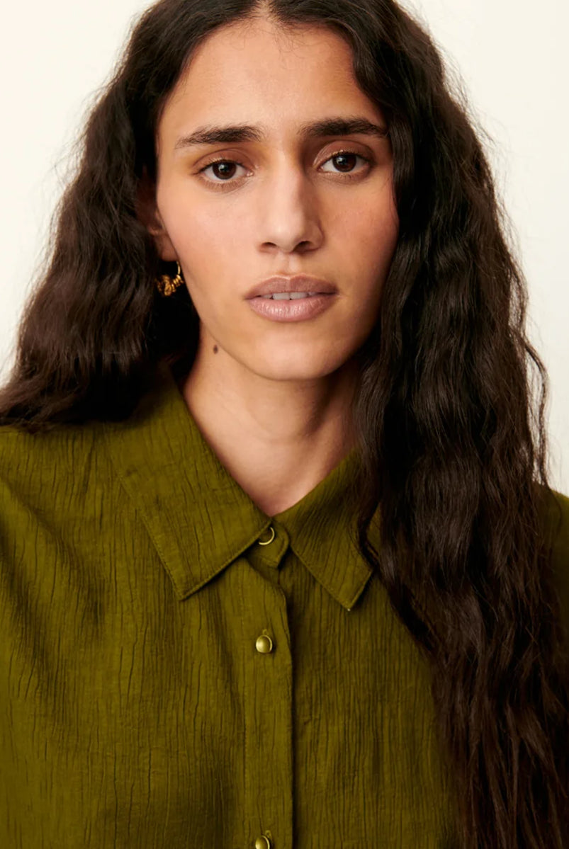 Luźna, krótka koszula Kayla Agave Green marki Sessun z klasycznym kołnierzykiem i krótkim rękawem z biżuteryjnymi guzikami przy mankietach. Zapinana z przodu na ozdobne guziki. Na plecach posiada płaskie zakładki, które dodają lekkości. Wykonana z mieszanki z wiskozą. To idealna propozycja na cieplejsze dni.
-Luźny, krótki fason
-Ozdobne guziki
-Zamów koszulę w swoim standardowym rozmiarze