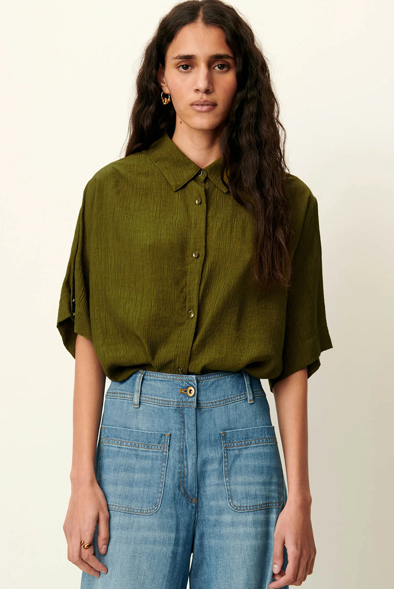Luźna, krótka koszula Kayla Agave Green marki Sessun z klasycznym kołnierzykiem i krótkim rękawem z biżuteryjnymi guzikami przy mankietach. Zapinana z przodu na ozdobne guziki. Na plecach posiada płaskie zakładki, które dodają lekkości. Wykonana z mieszanki z wiskozą. To idealna propozycja na cieplejsze dni.
-Luźny, krótki fason
-Ozdobne guziki
-Zamów koszulę w swoim standardowym rozmiarze