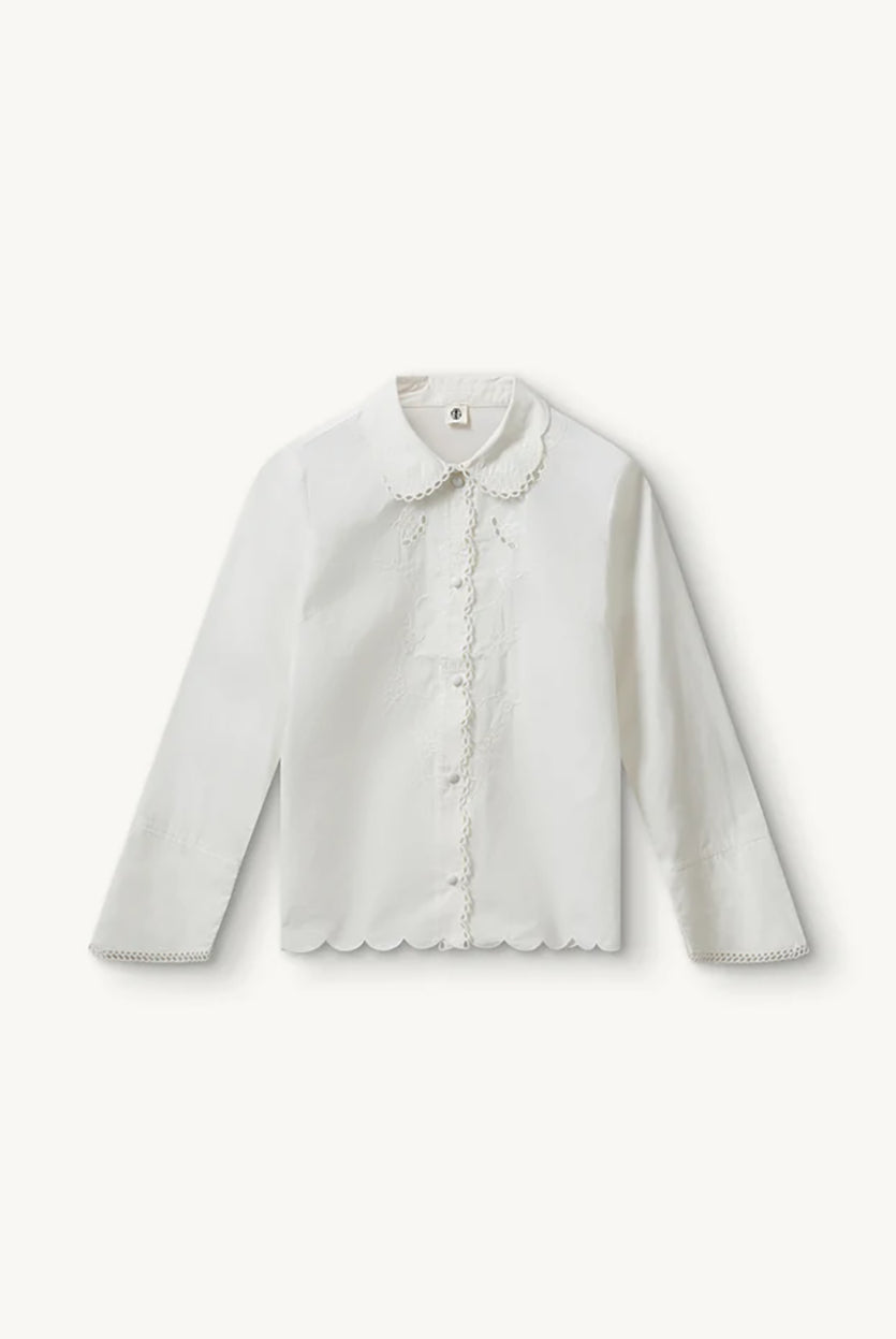 Romantyczna, klasyczna koszula Kirsten Collar White marki The Garment z zaokrąglonym kołnierzykiem z haftem angielskim i ażurowymi wycięciami. Posiada bardzo wysokie, eleganckie mankiety. Na piersiach i wzdłuż linii guzików znajdują się delikatne, kwiatowe hafty. Zapinana na drobne guziki. Brzeg koszuli oraz listwa guzikowa wykończone są falistym brzegiem. Wykonana z bawełny organicznej.
-Ozdobiona haftem angielskim
-Faliste brzegi
-Zamów koszulę w swoim standardowym rozmiarze