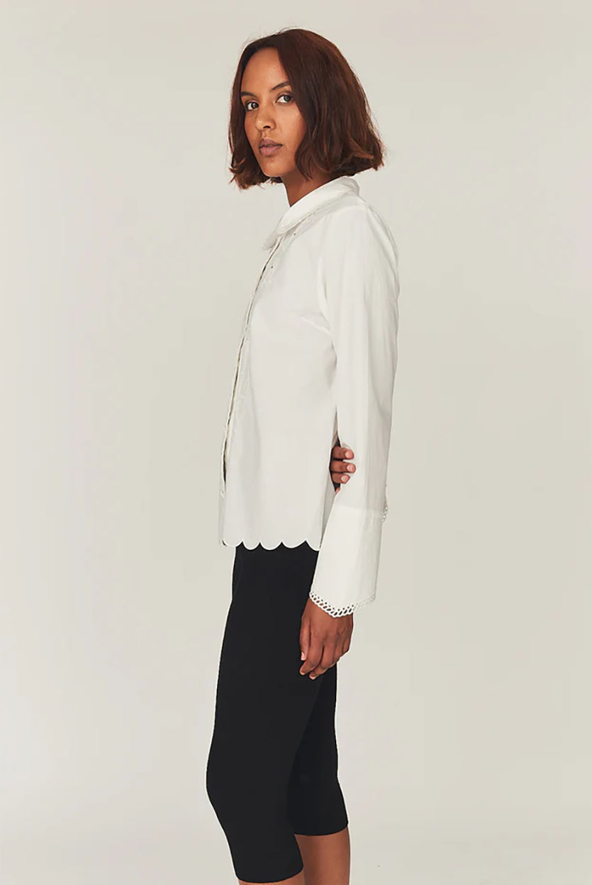 Romantyczna, klasyczna koszula Kirsten Collar White marki The Garment z zaokrąglonym kołnierzykiem z haftem angielskim i ażurowymi wycięciami. Posiada bardzo wysokie, eleganckie mankiety. Na piersiach i wzdłuż linii guzików znajdują się delikatne, kwiatowe hafty. Zapinana na drobne guziki. Brzeg koszuli oraz listwa guzikowa wykończone są falistym brzegiem. Wykonana z bawełny organicznej.
-Ozdobiona haftem angielskim
-Faliste brzegi
-Zamów koszulę w swoim standardowym rozmiarze