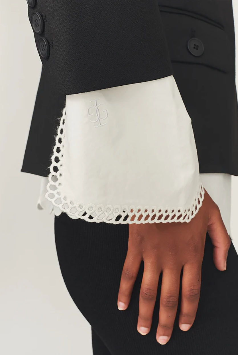 Romantyczna, klasyczna koszula Kirsten Collar White marki The Garment z zaokrąglonym kołnierzykiem z haftem angielskim i ażurowymi wycięciami. Posiada bardzo wysokie, eleganckie mankiety. Na piersiach i wzdłuż linii guzików znajdują się delikatne, kwiatowe hafty. Zapinana na drobne guziki. Brzeg koszuli oraz listwa guzikowa wykończone są falistym brzegiem. Wykonana z bawełny organicznej.
-Ozdobiona haftem angielskim
-Faliste brzegi
-Zamów koszulę w swoim standardowym rozmiarze