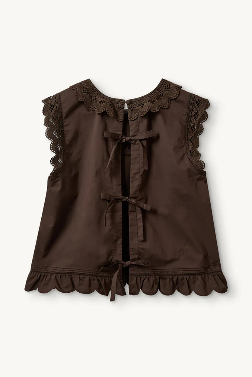 Swobodny, bawełniany top Kirsten Cloth Chocolate marki The Garment o lekko trapezowym kształcie. Ma okrągły dekolt wykończony szerokim, koronkowym kołnierzykiem. Podobne obszycia znajdują się wokół ramion, co tworzy efekt falbanki. Na piersi widoczny jest subtelny, ażurowy haft. Plecy są rozcięte i wiązane na trzy kokardki. Dół wykończony jest falistym brzegiem.
-Ażurowe hafty
-Tył wiązany na kokardki
-Bawełna organiczna
-Zamów top w swoim standardowym rozmiarze