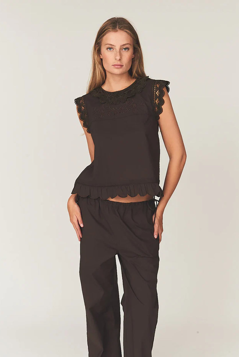 Swobodny, bawełniany top Kirsten Cloth Chocolate marki The Garment o lekko trapezowym kształcie. Ma okrągły dekolt wykończony szerokim, koronkowym kołnierzykiem. Podobne obszycia znajdują się wokół ramion, co tworzy efekt falbanki. Na piersi widoczny jest subtelny, ażurowy haft. Plecy są rozcięte i wiązane na trzy kokardki. Dół wykończony jest falistym brzegiem.
-Ażurowe hafty
-Tył wiązany na kokardki
-Bawełna organiczna
-Zamów top w swoim standardowym rozmiarze