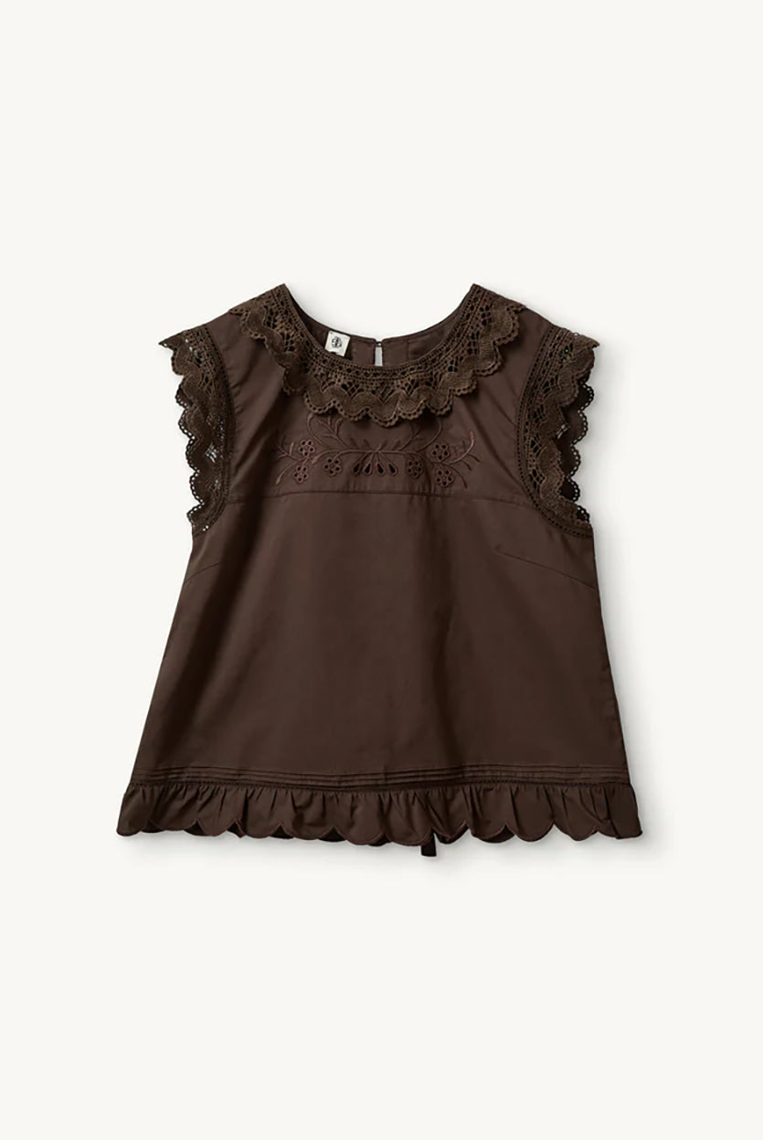 Swobodny, bawełniany top Kirsten Cloth Chocolate marki The Garment o lekko trapezowym kształcie. Ma okrągły dekolt wykończony szerokim, koronkowym kołnierzykiem. Podobne obszycia znajdują się wokół ramion, co tworzy efekt falbanki. Na piersi widoczny jest subtelny, ażurowy haft. Plecy są rozcięte i wiązane na trzy kokardki. Dół wykończony jest falistym brzegiem.
-Ażurowe hafty
-Tył wiązany na kokardki
-Bawełna organiczna
-Zamów top w swoim standardowym rozmiarze