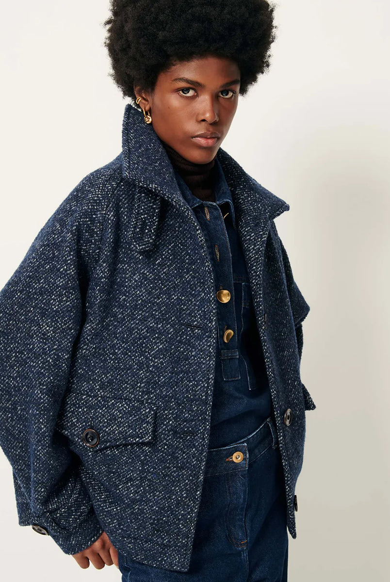 Luźny płaszcz wełniany typu bluza Lee Valley Denimwool marki Sessun wykonany z miękkiej, trójkolorowej tkaniny o splocie koszykowym, z efektem melanżowym. Posiada wysoki kołnierz, kieszenie oraz długie, raglanowe rękawy. Zapinany jest na duże guziki.