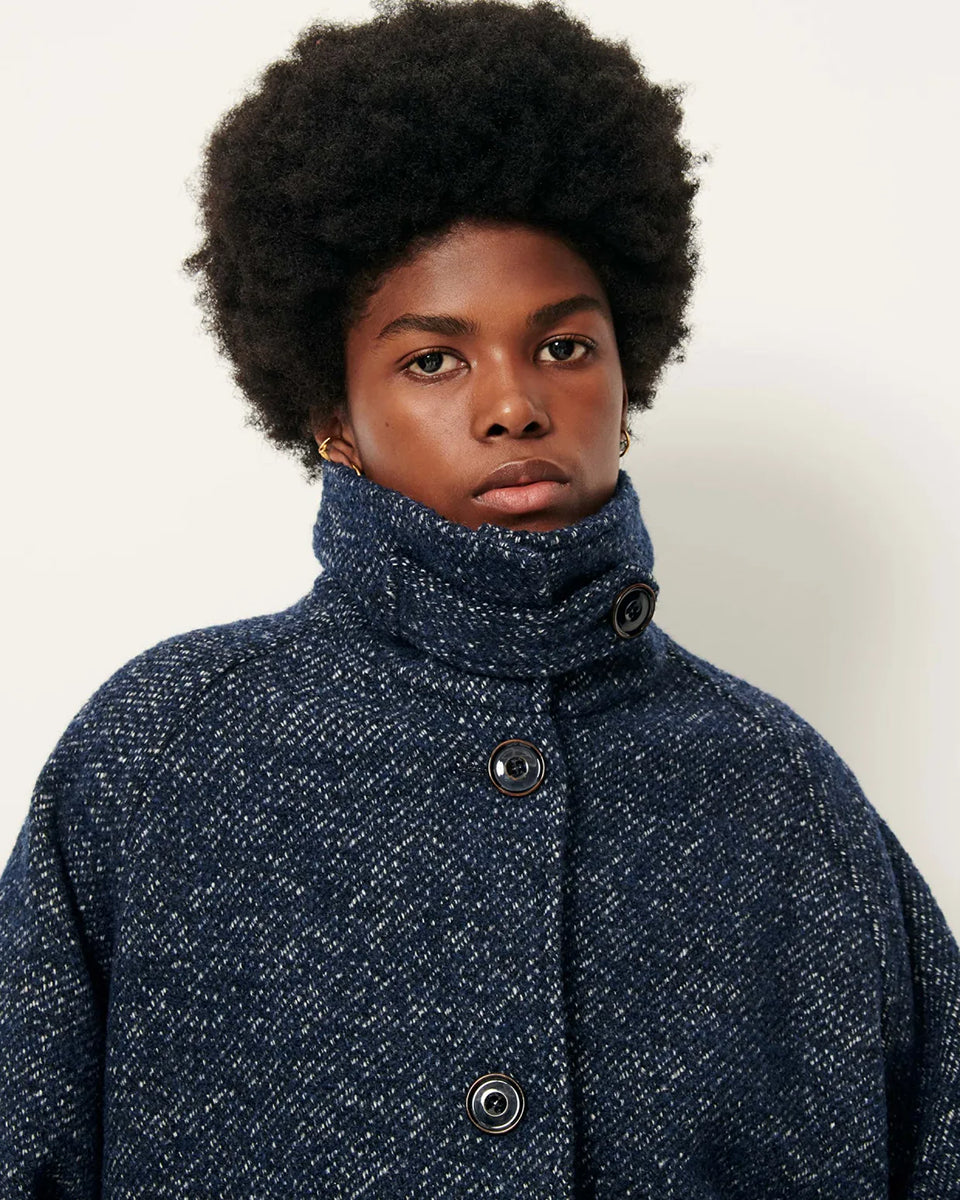 Luźny płaszcz wełniany typu bluza Lee Valley Denimwool marki Sessun wykonany z miękkiej, trójkolorowej tkaniny o splocie koszykowym, z efektem melanżowym. Posiada wysoki kołnierz, kieszenie oraz długie, raglanowe rękawy. Zapinany jest na duże guziki.