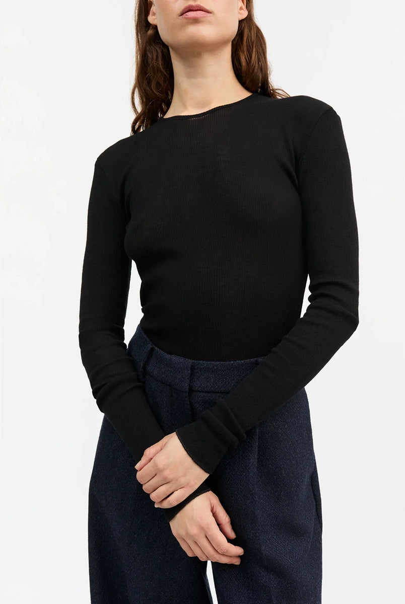 Minimalistyczny, cienki, wełniany longsleeve Amy O-neck SKALL z okrągłym dekoltem i wąskimi, długimi rękawami. Posiada przylegający do ciała fason i delikatną fakturę w prążki.