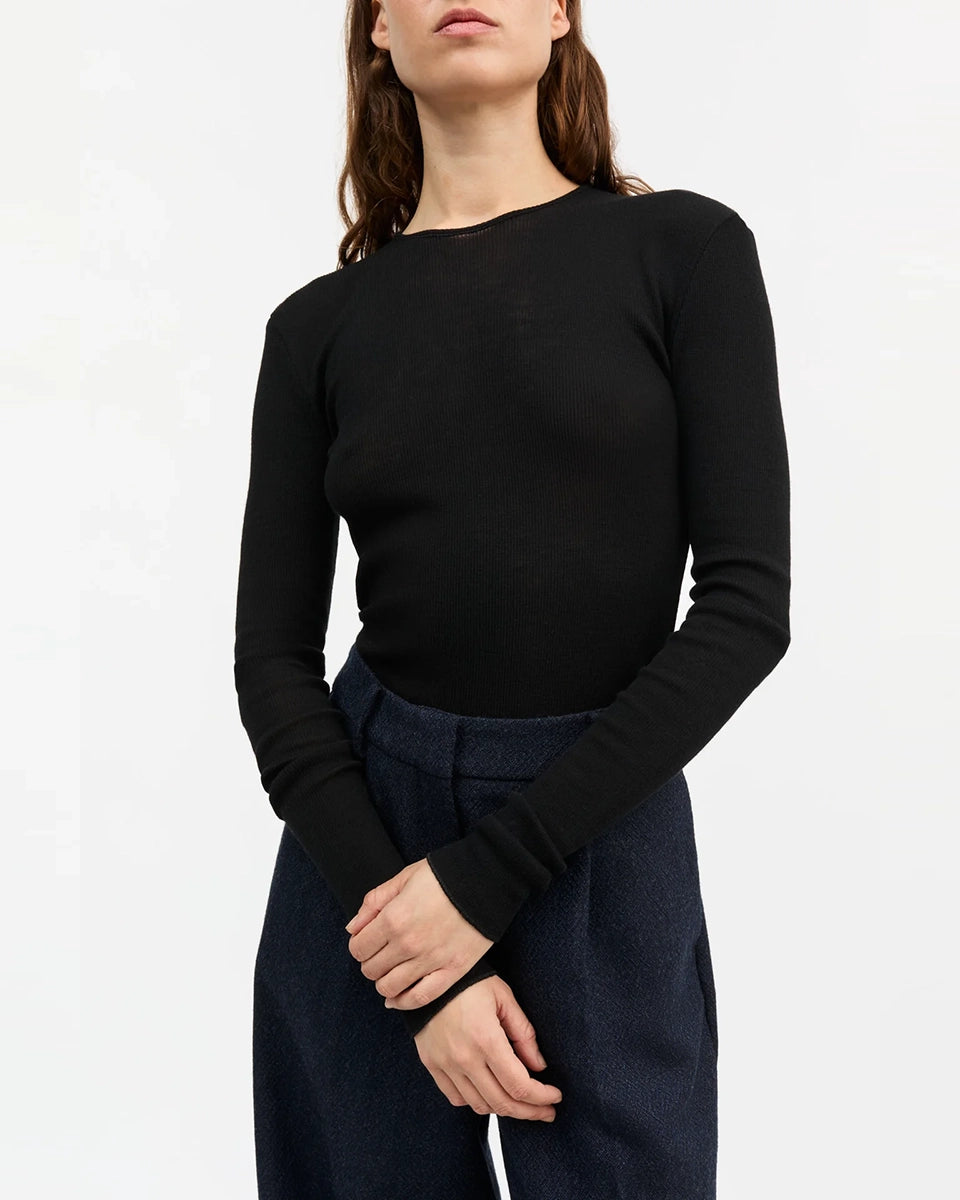 Minimalistyczny, cienki, wełniany longsleeve Amy O-neck SKALL z okrągłym dekoltem i wąskimi, długimi rękawami. Posiada przylegający do ciała fason i delikatną fakturę w prążki.