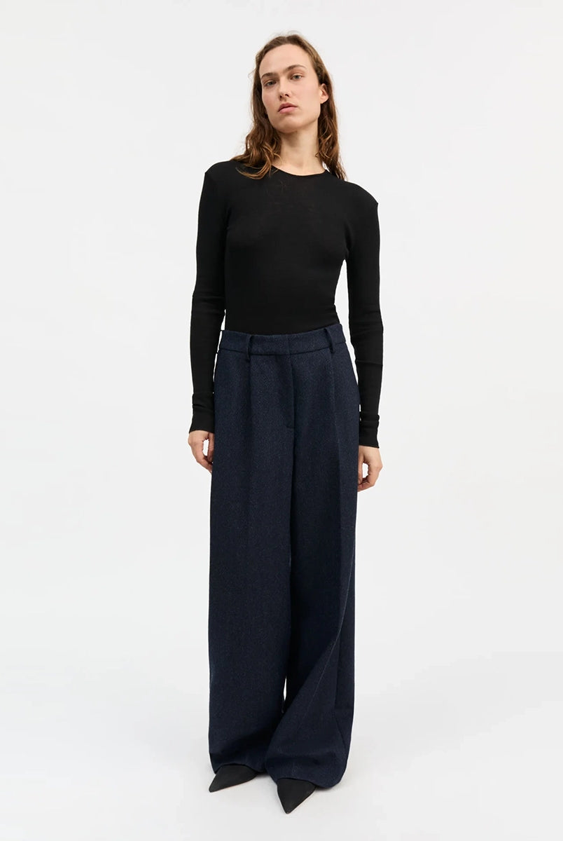 Minimalistyczny, cienki, wełniany longsleeve Amy O-neck SKALL z okrągłym dekoltem i wąskimi, długimi rękawami. Posiada przylegający do ciała fason i delikatną fakturę w prążki.