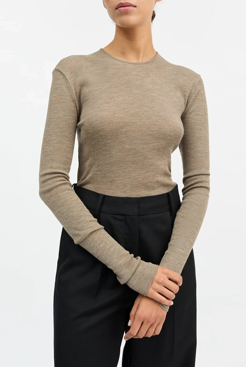 Minimalistyczny, cienki, wełniany longsleeve Amy O-neck SKALL z okrągłym dekoltem i wąskimi, długimi rękawami. Posiada przylegający do ciała fason i delikatną fakturę w prążki