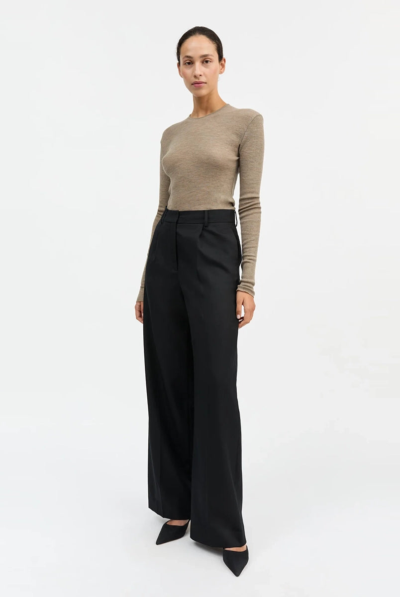 Minimalistyczny, cienki, wełniany longsleeve Amy O-neck SKALL z okrągłym dekoltem i wąskimi, długimi rękawami. Posiada przylegający do ciała fason i delikatną fakturę w prążki