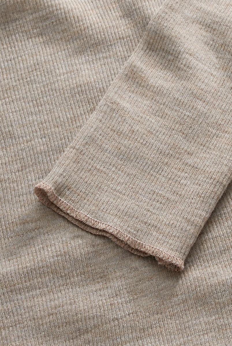 Minimalistyczny, cienki, wełniany longsleeve Amy O-neck SKALL z okrągłym dekoltem i wąskimi, długimi rękawami. Posiada przylegający do ciała fason i delikatną fakturę w prążki