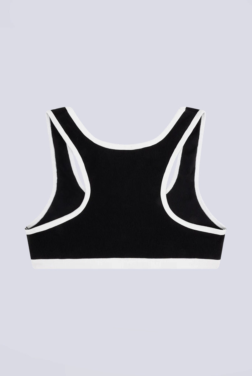 Miękki sportowy stanik top Rika Love Love Stories na grubych ramiączkach. Wykonany z miękkiej tkaniny z prążkowaną fakturą i białą, grubą lamówką. Na gumie pod biustem posiada niewielką naszywkę z logo marki. 