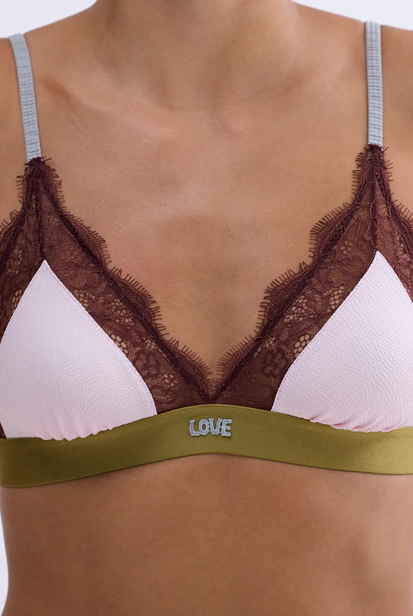 Delikatny, miękki stanik z trójkątnymi miseczkami Love Lace Love Stories. Wykonany z różowej, satynowej tkaniny. Miseczki obszyte są delikatną koronką. Stanik posiada szeroką gumę pod biustem oraz regulowane, marszczone ramiączka. Zapinany na plecach za pomocą haftek.